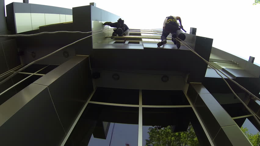 Operatori al lavoro su un balcone e una facciata