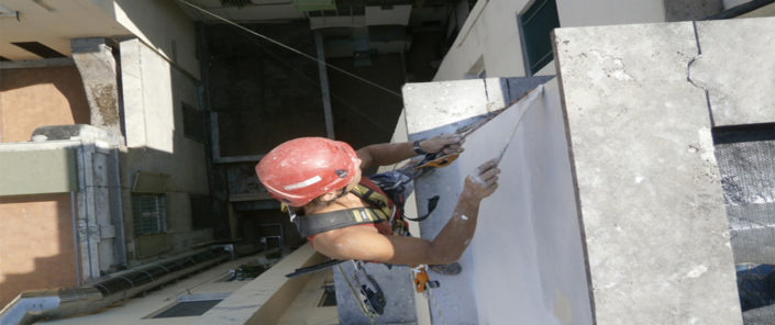 Operatore su fune dipinge una facciata a Viterbo