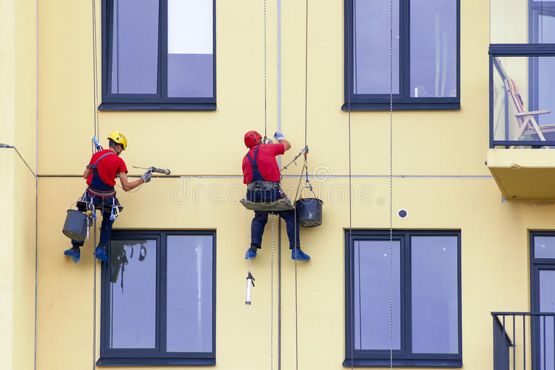 Tinteggiatura di una facciata lavorando su fune
